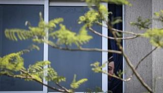  فلسطينية تشاهد من نافذتها جنازة ضحايا العملية الإسرائيلية