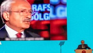 أردوغان، مع ظهور شريط فيديو لمنافسه كليجدار أوغلو، على الشاشة خلال حدث انتخابي 