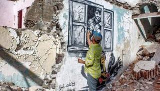 علاء روبيل يرسم إحدى جدارياته