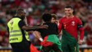 احتفلا سويا.. مشجع يباغت كريستيانو رونالدو في أرض الملعب (فيديو وصور)