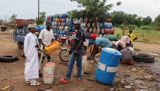 تاجر للوقود المهرب في نيجيريا يتحدث مع عمال - رويترز