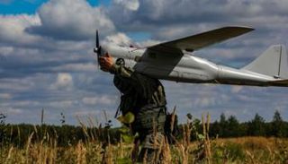 جندي روسي يحمل طائرة مسيرة