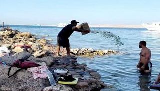 مصري يلقي زجاج مكسور في شواطئ الغردقة