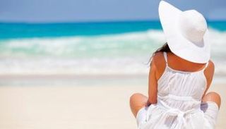 فتاة تجلس على شاطئ تحت أشعة الشمس المباشرة