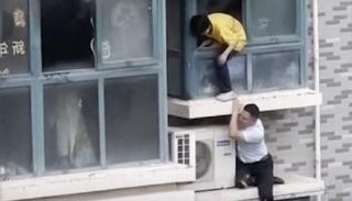 لقطة من فيديو لرجل صيني ينقذ طفلة من حريق