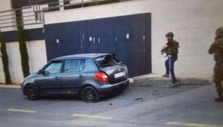 جنديان إسرائيليان بجوار سيارة الفلسطينيين القتلى