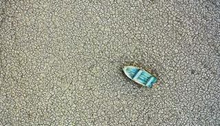 قارب في منطقة جافة في بحيرات هامون على الحدود بين أفغانستان وإيران