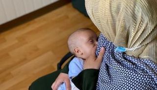 سيدة ترضع صغيرها طبيعيا