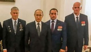  أندريه تروشيف على يمين بوتين خلال تكريمه