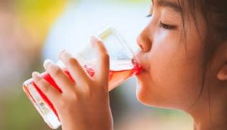 طفلة تتناول مشروبا