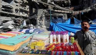 بائع فلسطيني يعرض منتجاته في سوق بمخيم النصيرات للاجئين وسط قطاع غزة