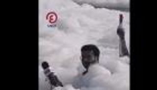 كأنه في حوض استحمام.. مراسل محاط برغوة كثيفة في نهر بالهند (فيديو)