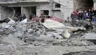 فلسطينيون يتجمعون في موقع غارة إسرائيلية على منزل