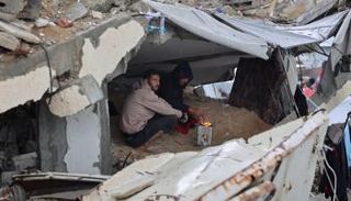 نازحون يشعلون النيران للتدفئة تحت الأنقاض