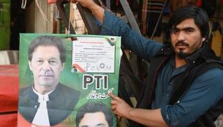 بائع يحمل ملصقا عليه صورة عمران خان