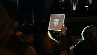 أشخاص يحملون لافتات خارج السفارة الروسية في واشنطن بعد وفاة زعيم المعارضة الروسية أليكسي نافالني