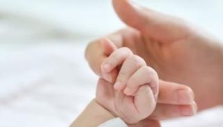 أم تمسك بيد وليدها