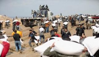 فلسطينيون قرب شاحنة مساعدات تحمل الطحين