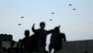 أطفال في قطاع غزة يراقبون إسقاط مساعدات إنسانية على قطاع غزة - رويترز