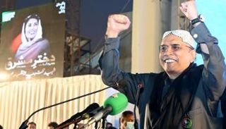 آصف علي زرداري وخلفه صورة لزوجته الراحلة بينظير بوتو