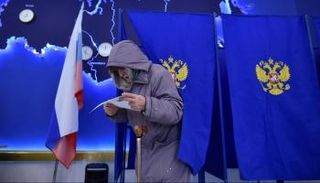 ناخبة روسية تتفحص ورقة الاقتراع