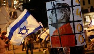 محتجون إسرائيليون يرفعون لافتة مناهضة لنتنياهو