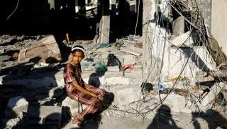 طفلة فلسطينية تجلس على ركام منزلهم في رفح