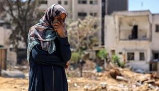 سيدة فلسطينية تشاهد أعمال البحث عن الجثث