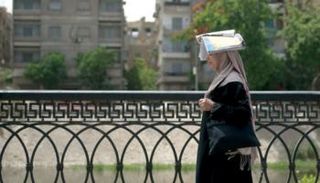 امرأة تحتمي بكتاب من حرارة الشمس في القاهرة - أرشيفية