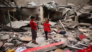 أطفال فوق ركام منزلهم المدمر بغزة