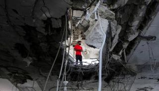 شاب فلسطيني في غزة يقف على أنقاض منزل في برفح