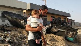 فلسطيني يتفقد قوارب متضررة من القصف في رفح