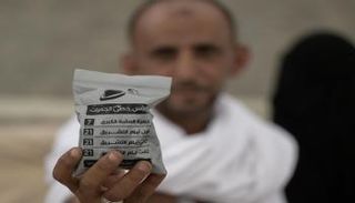 أحد الحجاج يمسك بكيس به جمرات