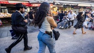 إسرائيلية تحمل مسدسا