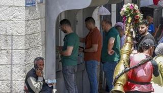 فلسطينيون يصطفون لسحب أموال في رام الله