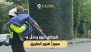 شرطي مرور يحمل مسنا لعبور الطريق في الصين