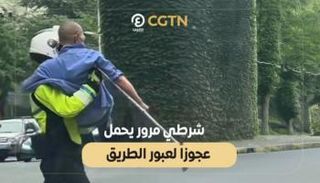 شرطي مرور يحمل عجوزاً لعبور الطريق