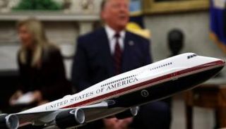 ترامب مع نموذج للطائرة الرئاسية بعد تغيير ألوانها