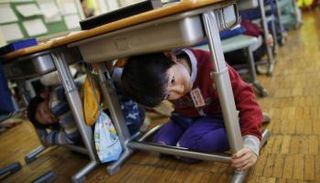 طفل يحتمي بطاولة في محاكاة لوقوع زلزال