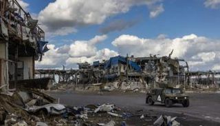 مدرعة أوكرانية تمر بجانب جسر روسي مدمر