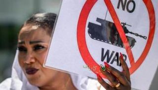 امرأة سودانية ترفع لافتة تنادي بوقف الحرب مع انطلاق محادثات سويسرا