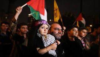 طفلة لبنانية على ذراع والدها في أحد شوارع بيروت