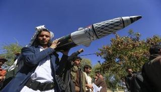 رجل يحمل صاروخًا وهميًا في صنعاء