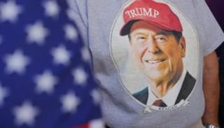 أمريكي يرتدي قميصا عليه صورة ريغان مع قبعة ترامب