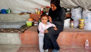 نازحة فلسطينية وابنتها في خان يونس