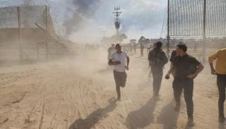 فلسطينيون يعبرون ثغرة في الجدار الفاصل بين غزة وإسرائيل يوم الهجوم