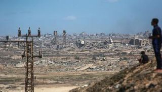 فلسطينيون يشاهدون تصاعد الدخان جراء الغارات الإسرائيلية على مخيم النصيرات 