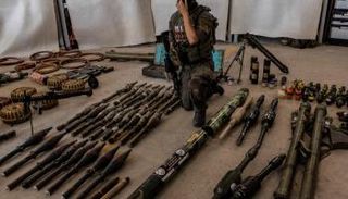 ضابط إسرائيلي يستعرض أسلحة لحماس