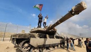 فلسطينيون يرفعون علم فلسطين فوق دبابة إسرائيلية يوم الهجوم