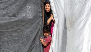 نازحة فلسطينية وابنتها بمخيم النصيرات
